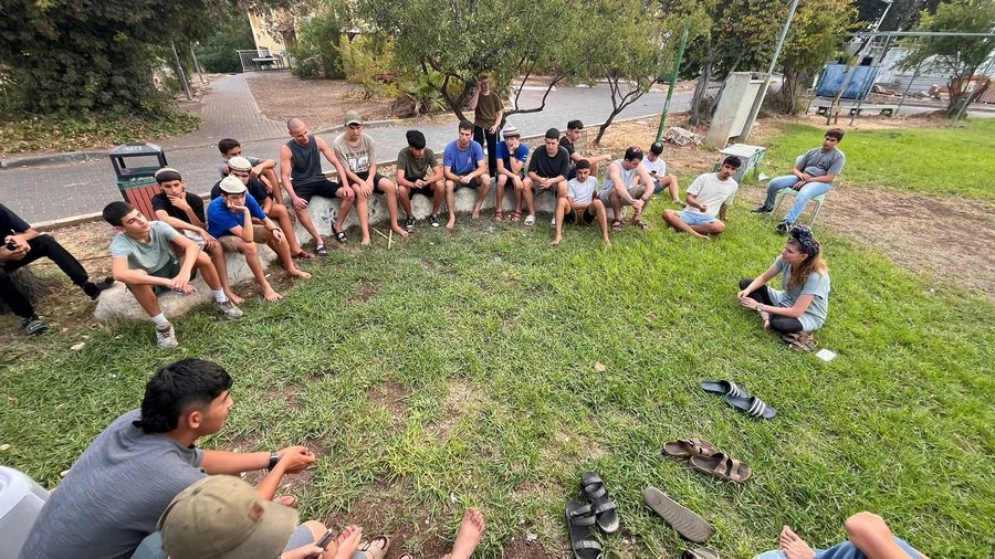 מפגש תלמידים במעגל על הדשא בכפר